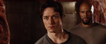 Movie still from “Wanted” (2008), directed by Timur Bekmambetov – A person wearing a gray shirt; Close Up shot, Low angle