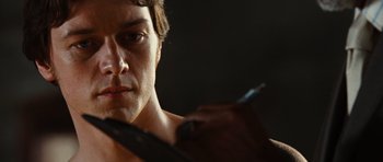Movie still from “Wanted” (2008), directed by Timur Bekmambetov – A person holding a pen in his hand; Close Up shot, Over the shoulder angle
