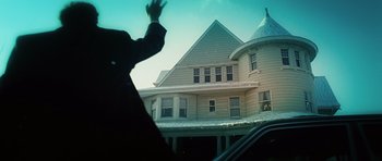 Movie still from “Wanted” (2008), directed by Timur Bekmambetov – A man waving from a car in front of a large house; Wide shot, Low angle