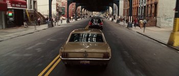 Movie still from “Wanted” (2008), directed by Timur Bekmambetov – Two cars driving down a street under an overpass; Wide shot, High angle