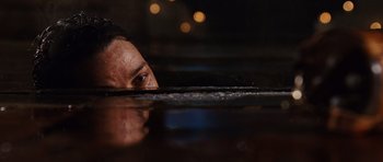 Movie still from “Wanted” (2008), directed by Timur Bekmambetov – A person with a wet face in a body of water at night; Close Up shot, Overhead angle