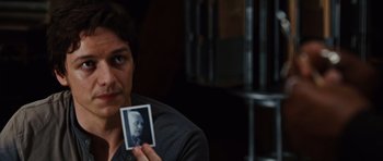 Movie still from “Wanted” (2008), directed by Timur Bekmambetov – A man holding up a picture of a man; Close Up shot, Over the shoulder angle