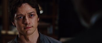 Movie still from “Wanted” (2008), directed by Timur Bekmambetov – A man's face in a dark room; Close Up shot, Over the shoulder angle