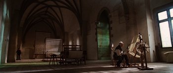 Movie still from “Wanted” (2008), directed by Timur Bekmambetov – A man sitting on a chair in a room; Wide shot, Low angle