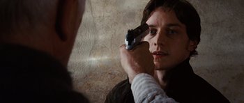 Movie still from “Wanted” (2008), directed by Timur Bekmambetov – A man holding a gun up to his face; Close Up shot, Over the shoulder angle