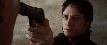 Movie still from “Wanted” (2008), directed by Timur Bekmambetov – A man holding a gun in his hand; Close Up shot, Low angle