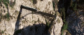 Movie still from “Wanted” (2008), directed by Timur Bekmambetov – A train is crossing a bridge over a river; Extreme Wide shot, Overhead angle