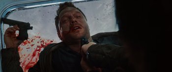 Movie still from “Wanted” (2008), directed by Timur Bekmambetov – A man is holding a gun and is bleeding from his face; Close Up shot, High angle
