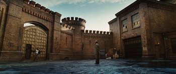 Movie still from “Wanted” (2008), directed by Timur Bekmambetov – A man standing in front of a brick building; Extreme Wide shot, Low angle
