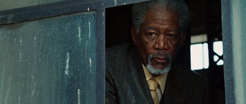 Movie still from “Wanted” (2008), directed by Timur Bekmambetov – An older man wearing a suit and tie looking out a window; Close Up shot, Low angle