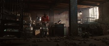 Movie still from “Wanted” (2008), directed by Timur Bekmambetov – A person standing in a room holding a knife; Wide shot, High angle