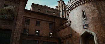 Movie still from “Wanted” (2008), directed by Timur Bekmambetov – A brick building with a clock on the side of it; Extreme Wide shot, Low angle