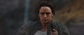 Movie still from “Wanted” (2008), directed by Timur Bekmambetov – A man holding a gun while standing in front of a window; Close Up shot, Low angle