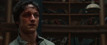 Movie still from “Wanted” (2008), directed by Timur Bekmambetov – A person in a room with a book shelf in the background; Close Up shot, Low angle