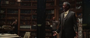 Movie still from “Wanted” (2008), directed by Timur Bekmambetov – Two men standing in front of bookshelves in a library; Medium shot, Low angle