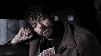 Movie still from “Z Nation” (2014), created by Karl Schaefer – A man holding a deck of playing cards in his hand; Close Up shot, Over the shoulder angle