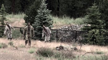 Movie still from “Z Nation” (2014), created by Karl Schaefer – Two men standing in the grass next to a tree; Wide shot, Over the shoulder angle