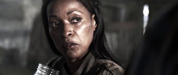 Movie still from “Z Nation” (2014), created by Karl Schaefer – A person wearing a military uniform; Close Up shot, Over the shoulder angle