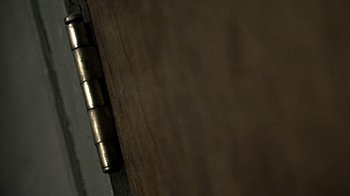 Movie still from “Z Nation” (2014), created by Karl Schaefer – A wooden table with a metal hinge; Extreme Close Up shot, Overhead angle