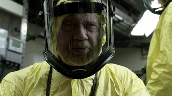 Movie still from “Z Nation” (2014), created by Karl Schaefer – A man in a yellow suit and a face shield; Close Up shot, Low angle