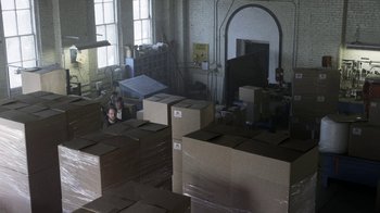 Movie still from “Z Nation” (2014), created by Karl Schaefer – A room filled with lots of cardboard boxes; Extreme Wide shot, High angle