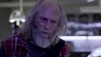 Movie still from “Z Nation” (2014), created by Karl Schaefer – An old man with a beard and a red plaid shirt; Close Up shot, Low angle