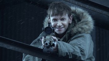 Movie still from “Z Nation” (2014), created by Karl Schaefer – A man holding a gun while standing in the snow; Close Up shot, Over the shoulder angle