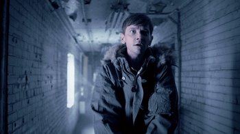 Movie still from “Z Nation” (2014), created by Karl Schaefer – A young man in a jacket in a dark hallway; Close Up shot, Low angle