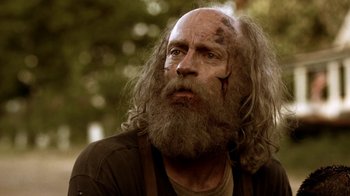 Movie still from “Z Nation” (2014), created by Karl Schaefer – An old man with a beard and long hair; Close Up shot, Low angle