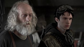 Movie still from “Z Nation” (2014), created by Karl Schaefer – A man with a beard standing next to a man with long hair; Close Up shot, Over the shoulder angle