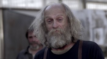 Movie still from “Z Nation” (2014), created by Karl Schaefer – An old man with long white hair and a beard; Close Up shot, Low angle