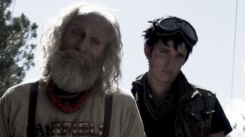 Movie still from “Z Nation” (2014), created by Karl Schaefer – A man and a boy standing next to each other; Close Up shot, Over the shoulder angle