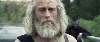 Movie still from “Z Nation” (2014), created by Karl Schaefer – An old man with long white beard and a beard; Close Up shot, Low angle