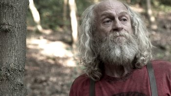 Movie still from “Z Nation” (2014), created by Karl Schaefer – An old man with long white hair and a long beard; Close Up shot, Over the shoulder angle