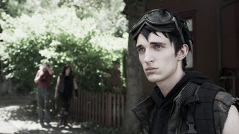 Movie still from “Z Nation” (2014), created by Karl Schaefer – A young man wearing goggles in front of a woman; Close Up shot, Over the shoulder angle