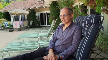 Movie still from “Creep 2” (2017), directed by Patrick Brice – An older man sitting on a lawn chair outside; Medium shot, High angle
