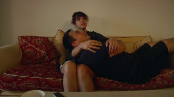 Movie still from “Creep 2” (2017), directed by Patrick Brice – A man and a woman sitting on a couch together; Medium shot, High angle