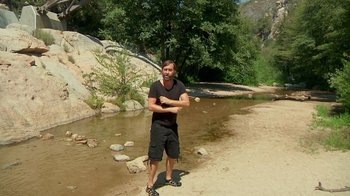 Movie still from “Creep 2” (2017), directed by Patrick Brice – A man standing next to a body of water; Wide shot, High angle