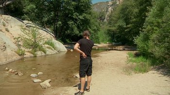 Movie still from “Creep 2” (2017), directed by Patrick Brice – A man standing in the middle of a river; Wide shot, High angle