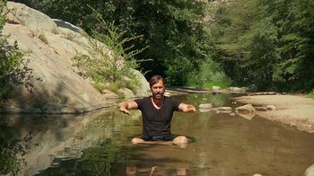 Movie still from “Creep 2” (2017), directed by Patrick Brice – A man sitting in the middle of a river; Wide shot, High angle