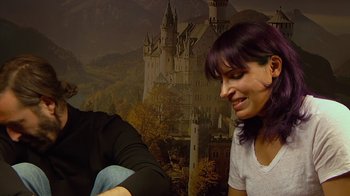 Movie still from “Creep 2” (2017), directed by Patrick Brice – A woman sitting next to another woman in front of a castle; Close Up shot, Over the shoulder angle