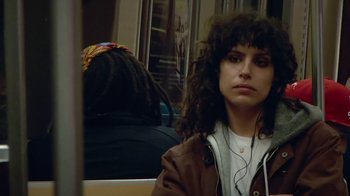 Movie still from “Creep 2” (2017), directed by Patrick Brice – A woman sitting on a subway train listening to music; Close Up shot, High angle