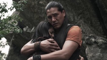 Movie still from “Z Nation” (2014), created by Karl Schaefer – A man and a woman hugging in front of a rock wall; Close Up shot, Over the shoulder angle