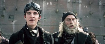 Movie still from “Z Nation” (2014), created by Karl Schaefer – A man and a man with long hair and a beard; Close Up shot, Low angle