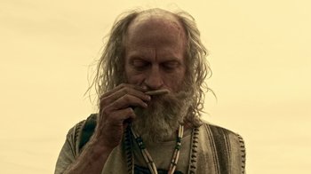 Movie still from “Z Nation” (2014), created by Karl Schaefer – An old man with long white hair and a long beard; Close Up shot, Low angle
