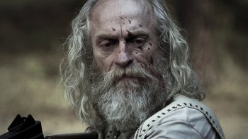 Movie still from “Z Nation” (2014), created by Karl Schaefer – An old man with white hair and a long beard; Close Up shot, Over the shoulder angle