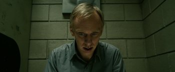 Movie still from “Zombieland” (2009), directed by Ruben Fleischer – A man in a gray shirt is looking at the camera; Close Up shot, Low angle