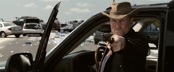 Movie still from “Zombieland” (2009), directed by Ruben Fleischer – A man in a hat is holding a camera in a car; Close Up shot, Over the shoulder angle