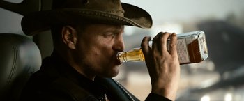 Movie still from “Zombieland” (2009), directed by Ruben Fleischer – A man in a cowboy hat drinking a beer; Close Up shot, Low angle