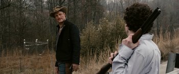 Movie still from “Zombieland” (2009), directed by Ruben Fleischer – A man wearing a cowboy hat standing next to another man; Medium shot, Over the shoulder angle